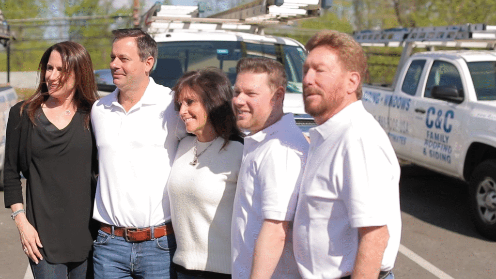 C&C Family Roofing & Siding team members posing in front of branded service trucks