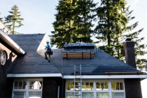Elite Roofing crew installing a new asphalt shingle roof on a residential home using professional roofing equipment.