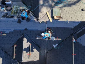 Roofing contractors installing asphalt shingles on a residential roof